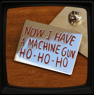 NOW I HAVE A MACHINE GUN HO-HO-HO - HARD ENAMEL BADGE